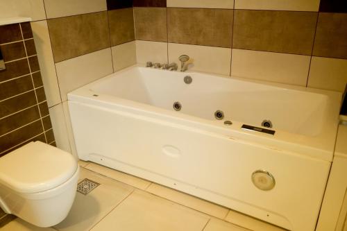 a white bath tub in a bathroom with a toilet at Casa de Amor Home Of Love in Ambalavayal