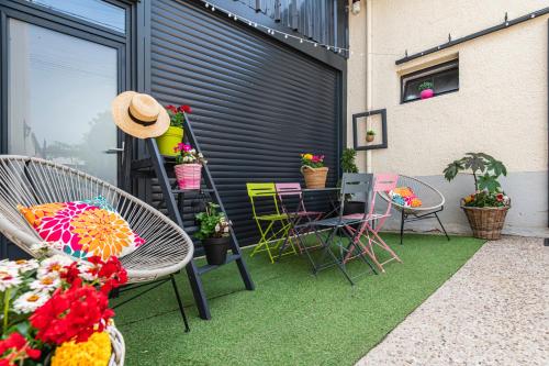 a patio with chairs and a table and some plants at Gîte de la Liberté in Vinay