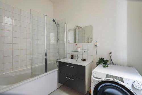 une salle de bain avec une machine à laver et un lave-linge dans l'établissement The Jeanne d'Arc - Center - Cathedral, à Reims