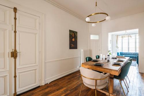une salle à manger avec une table et des chaises en bois dans l'établissement The Jeanne d'Arc - Center - Cathedral, à Reims