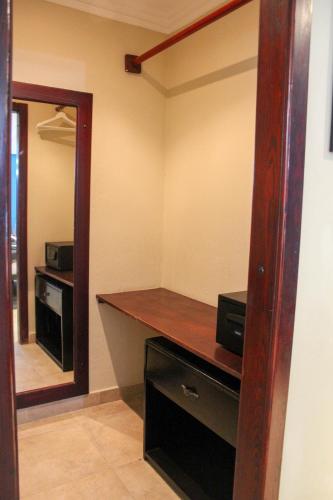 a room with a desk and a mirror in a room at hotel plaza BRISAS MT in Punta Cana