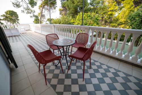a patio with four chairs and a table on a balcony at Park Hotel Villa Maria in San Menaio