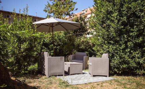 a group of chairs and an umbrella at La Casa dell'Artista - 3' dal mare in Albinia