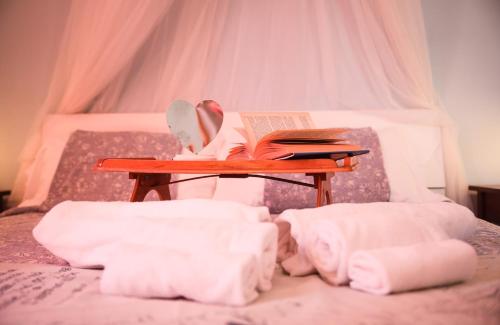 a bed with a table with a book and a book at La Casa dell'Artista - 3' dal mare in Albinia