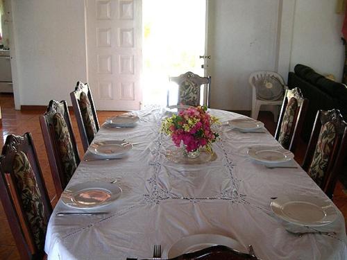 a table with a white table cloth and flowers on it at Maranatha villa in Discovery Bay