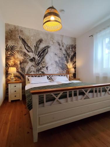 a bedroom with a large bed with a tropical wallpaper at Calma Apartment in Weimar