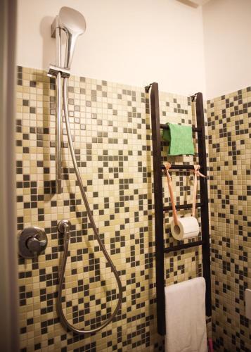a bathroom with a shower with a tiled wall at La Casa dell'Artista - 3' dal mare in Albinia