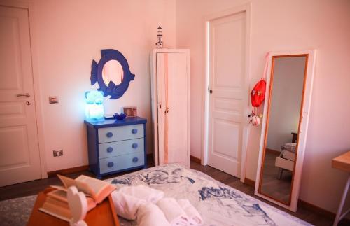 a bedroom with a bed and a mirror and a dresser at La Casa dell'Artista - 3' dal mare in Albinia