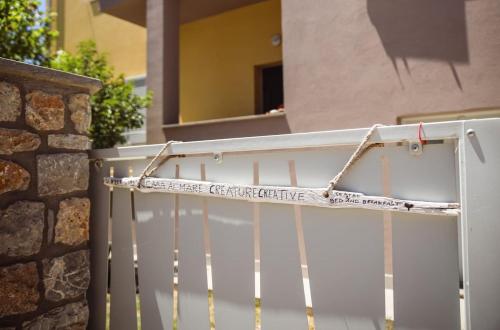 a white gate with a sign on it at La Casa dell'Artista - 3' dal mare in Albinia