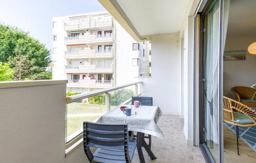 ein Balkon mit Tisch und Stühlen und einem Fenster in der Unterkunft Bel Appartement Proche Mer in Royan