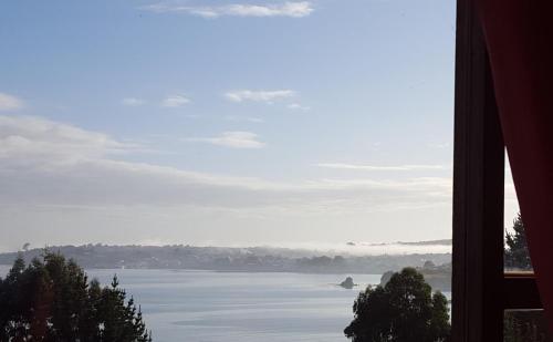 a view of a lake from a window at Hostal Vista al Mar hct in Ancud