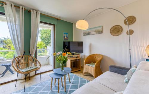 un salon avec un canapé, des chaises et une télévision dans l'établissement Bel Appartement Proche Mer, à Royan