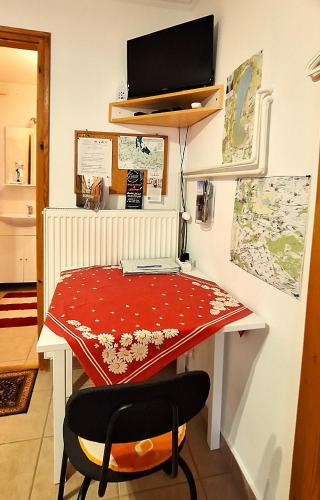 a desk with a red table and a chair at Júlia Vendégház Sarród in Sarród