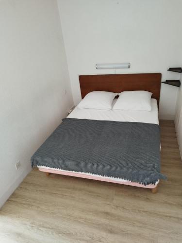 une chambre avec un lit avec une tête de lit en bois dans l'établissement Studio cosy avec vue exceptionnelle sur l'étang de Thau, à Balaruc-les-Bains