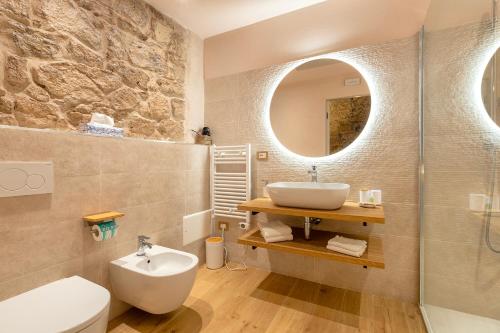 a bathroom with a sink toilet and a mirror at PedrAmare Suite in Alghero