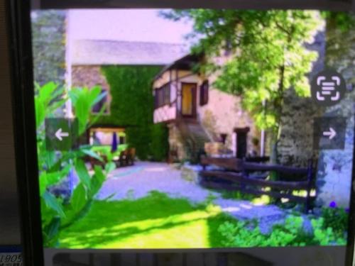 un écran de télévision avec une photo d'une maison dans l'établissement ecrin du segala, à La Celle-sous-Gouzon