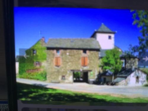 un grand bâtiment en pierre avec une tour en haut dans l'établissement ecrin du segala, à La Celle-sous-Gouzon