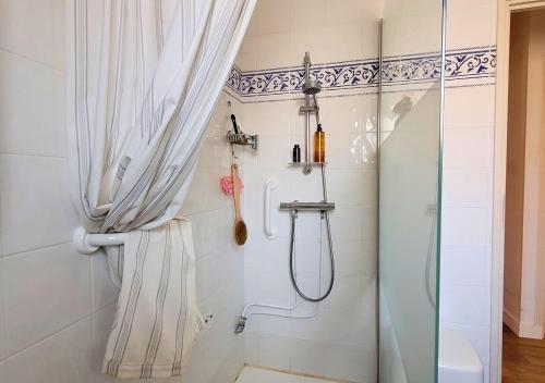 une douche avec une porte vitrée dans une salle de bain dans l'établissement GALLEBEN - Coquette et confortable maison, à Capbreton
