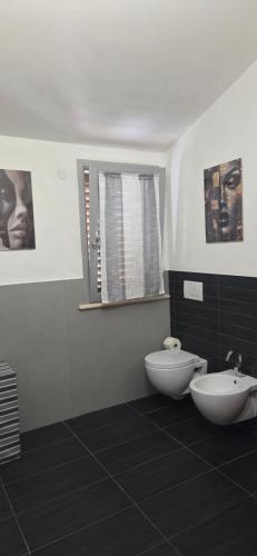a bathroom with a sink and a toilet and a window at Appartamento in villa Gra&Mary in San Giovanni in Marignano