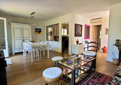 un salon avec une table et une salle à manger dans l'établissement GALLEBEN - Coquette et confortable maison, à Capbreton