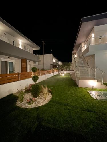 a yard of a house at night with lights at Siesta Thassos - Luxury Apartment in Skala Rachoniou
