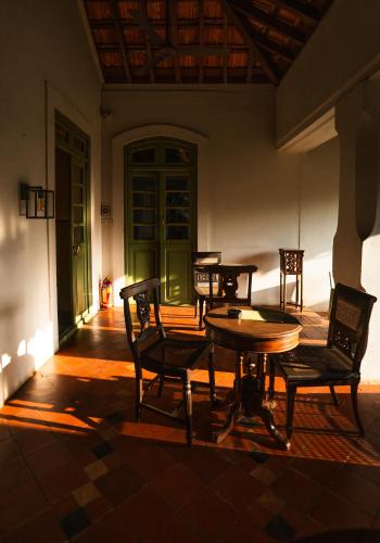 a patio with tables and chairs in a building at The Project Cafe and Hotel in Aldona