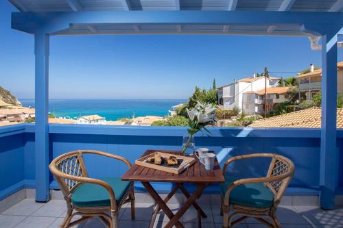 a table and chairs on a balcony with a view of the ocean at Pantazis Studios in Agios Nikitas in Agios Nikitas