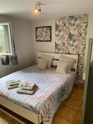 une chambre avec un lit avec des serviettes dessus dans l'établissement Maisonnette climatisée avec piscine et plage à 6mn, à Labenne
