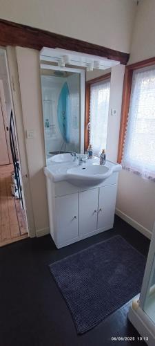 une salle de bain avec un lavabo blanc et un miroir dans l'établissement Aux volets bleus, à Conty