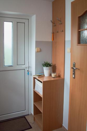 a room with a door and a desk with a plant at Apartamenty Tercet, Apartament Kwartet, Apartament DUO in Ustka
