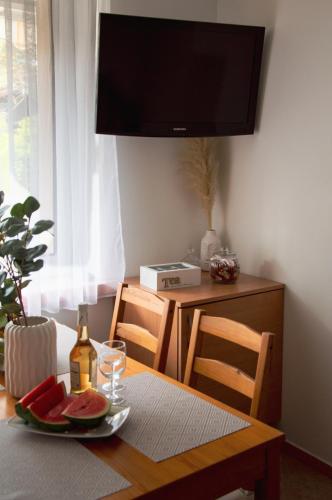 a table with a plate of watermelon and a bottle of wine at Apartamenty Tercet, Apartament Kwartet, Apartament DUO in Ustka
