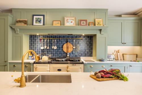 a kitchen with a sink and a counter with vegetables on it at The Old Vicarage in Hinton Saint George