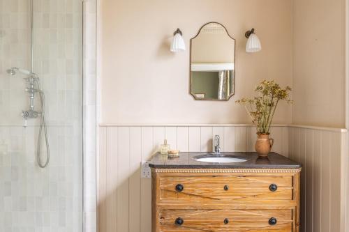a bathroom with a sink and a mirror at The Old Vicarage in Hinton Saint George