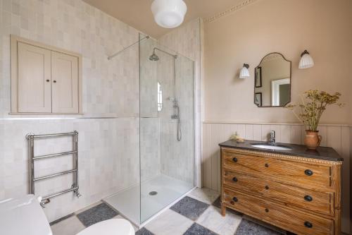 a bathroom with a shower and a sink and a mirror at The Old Vicarage in Hinton Saint George