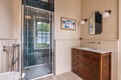 a bathroom with a tub and a sink and a shower at The Old Vicarage in Hinton Saint George