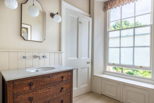 a bathroom with a sink and a window at The Old Vicarage in Hinton Saint George
