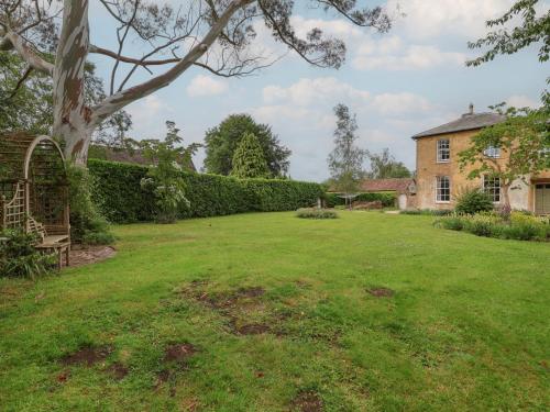 a yard of a house with a large lawn at The Old Vicarage in Hinton Saint George