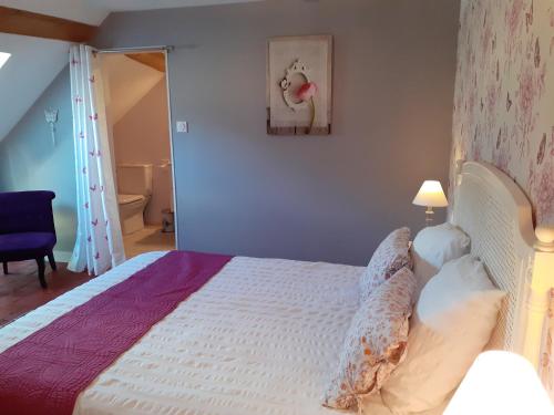 a bedroom with a bed with a white bedspread at couet et cafe in Seigy