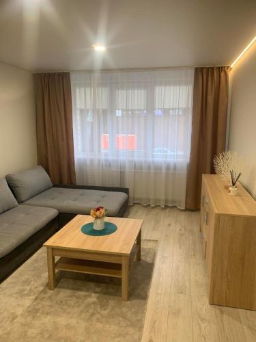 un soggiorno con un divano e un tavolino da caffè di Studio IT on Tumo a Plungė