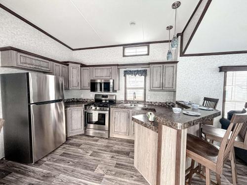 a kitchen with wooden cabinets and a stainless steel refrigerator at Bobcaygeon Shores Cottage Resort in Kawartha Lakes