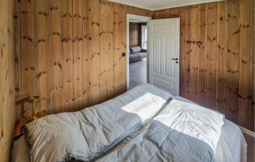 a bed in a room with wooden walls at Nice Home In Hafslo With Wifi in Hafslo