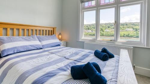 a bedroom with a bed with blue pillows on it at Brig y Don Menai in Menai Bridge