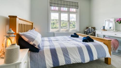 a bedroom with a bed with blue and white sheets at Brig y Don Menai in Menai Bridge