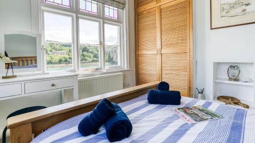 a bedroom with a bed with blue pillows on it at Brig y Don Menai in Menai Bridge