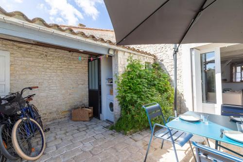 un vélo garé à côté d'un bâtiment avec un parapluie dans l'établissement 990 La Clairière Charm and authenticity, au Bois-Plage-en-Ré