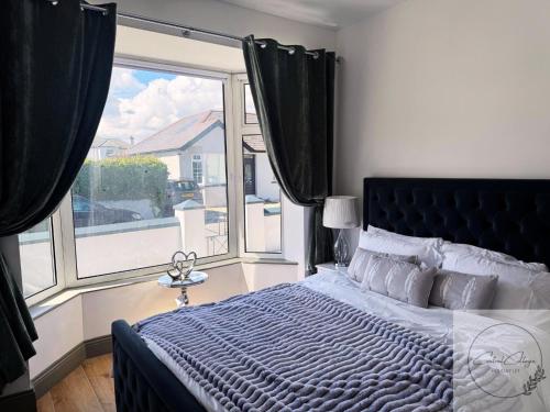 a bedroom with a large bed and a large window at Central cottage Newcastle in Newcastle