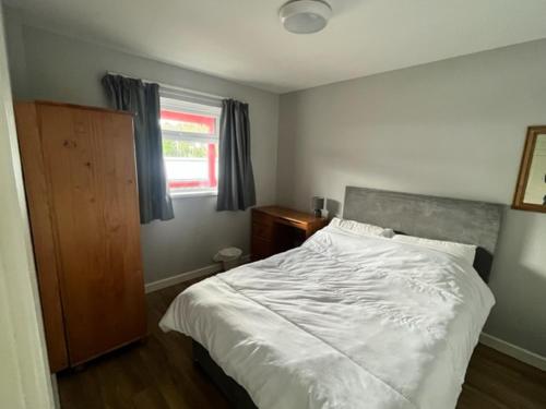 a bedroom with a white bed and a window at Causeway Coast Apartment in Ballycastle