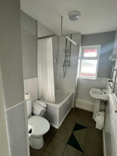 a white bathroom with a toilet and a sink at Causeway Coast Apartment in Ballycastle