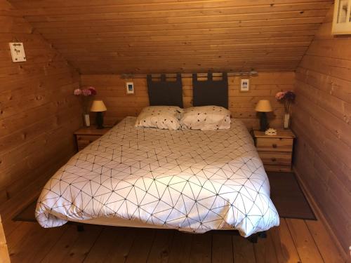 une chambre avec un lit dans une cabane en bois dans l'établissement la teste de buch chalet 143 ds domaine loisirs, à La Teste-de-Buch