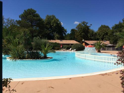 une grande piscine entourée d'une clôture blanche. dans l'établissement la teste de buch chalet 143 ds domaine loisirs, à La Teste-de-Buch
